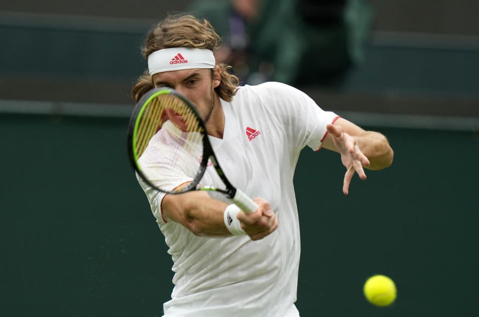 Stefanos Tsitsipas of Greece returns the ball to Frances Tiafoe of the US during the men's singles match on day one of the Wimbledon Tennis Championships in London, Monday June 28, 2021. (AP Photo/Alastair Grant)