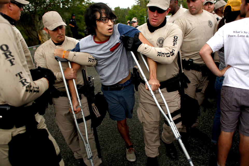 <p>A man protests as he is carried away by members of the Florida Highway Patrol from the entrance to a planned speech by white nationalist Richard Spencer, who popularized the term ‘alt-right’, after being refused tickets by members of Spencer’s security team, not pictured, at the University of Florida campus on Oct.19, 2017 in Gainesville, Fla. (Photo: Brian Blanco/Getty Images) </p>