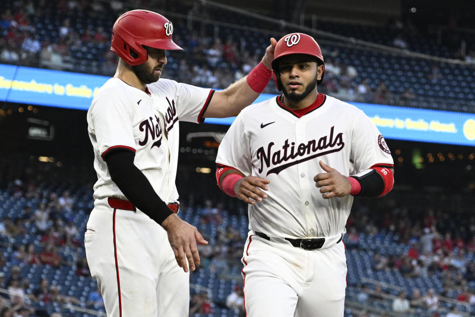Washington Nationals' Joey Gallo, left, greets Keibert Ruiz, right, after they scored on a single by Jacob Young during the fifth inning of a baseball game against the Minnesota Twins, Monday, May 20, 2024, in Washington. (AP Photo/Nick Wass)