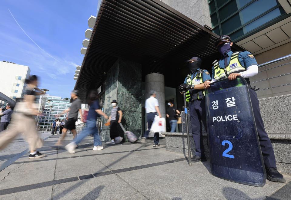 Police officers stand guard near the Seohyeon subway station in Seongnam, South Korea, Friday, Aug. 4, 2023. A man rammed a car onto a sidewalk Thursday and then stepped out of the vehicle and began stabbing people near the subway station in the city of Seongnam. On Friday, South Korean police are chasing the suspect in a stabbing attack in at a high school in the central city of Daejeon. (Hong Ji-won/Yonhap via AP)