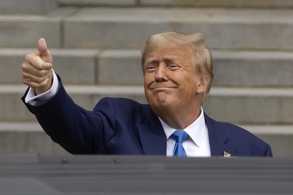 Former President Donald Trump gives a thumbs-up to supporters as he leaves the New Hampshire Statehouse after signing papers to get on the Republican presidential primary ballot, Monday, Oct. 23, 2023, in Concord, N.H. (AP Photo/Michael Dwyer)