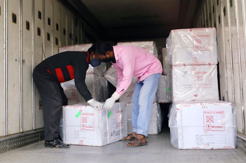 Workers unload a pickup van that carries Oxford-Astrazeneca COVID-19 vaccines which arrived from India as a gift to Bangladesh, in Dhaka