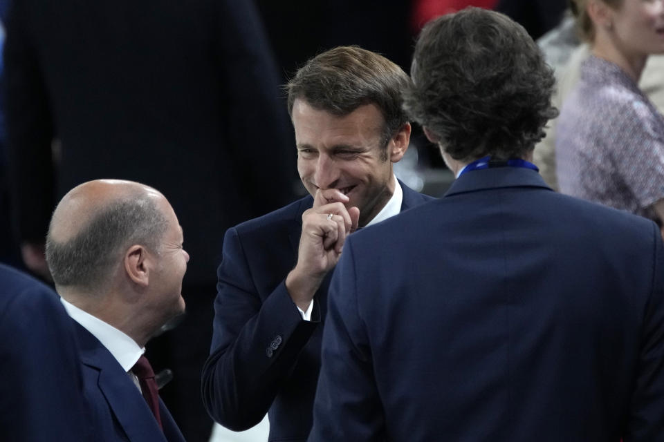 French President Emmanuel Macron, center, talks to German Chancellor Olaf Scholz, left, at the start of the session during the NATO summit Thursday, June 30, 2022 in Madrid. North Atlantic Treaty Organization heads of state are meeting for the final day of a NATO summit in Madrid on Thursday. (AP Photo/Christophe Ena, Pool)