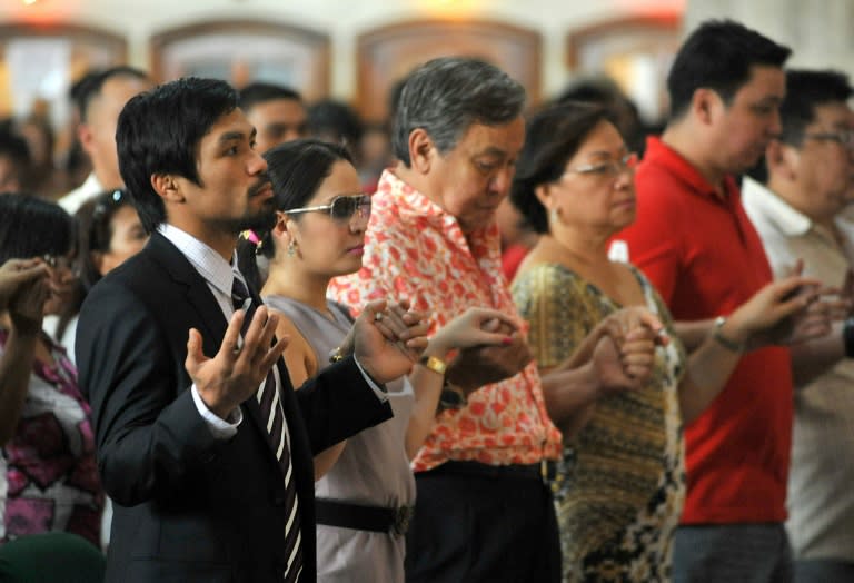 Philippine boxing hero Manny Pacquiao (L) holds his wife Jinkee's hand as they attend a mass at the Quiapo church in Manila, in 2010