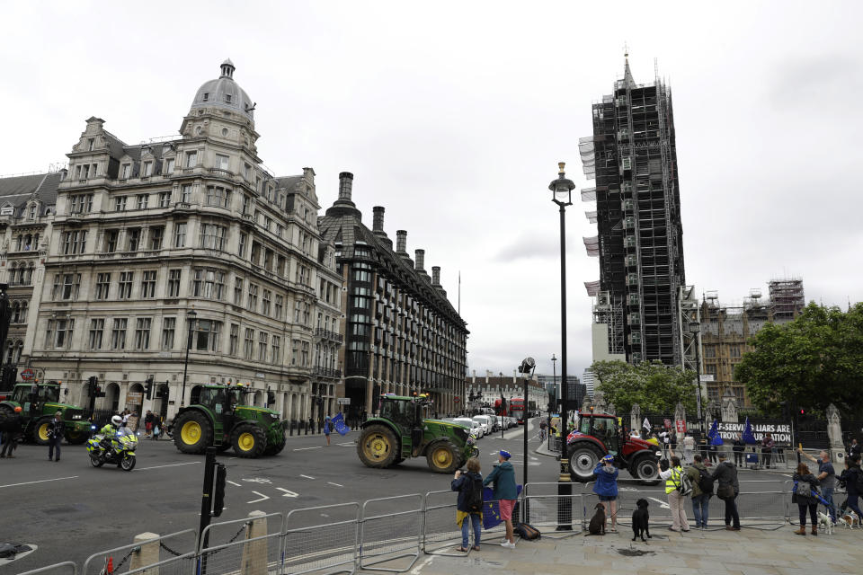 Farmers from the group Save British Farming drive tractors around Parliament Square, backdropped by the Houses of Parliament, at right, and the scaffolded Big Ben tower in London, in a protest against cheaply produced lower standard food being imported from the U.S. after Brexit that will undercut them, Wednesday, July 8, 2020. (AP Photo/Matt Dunham)