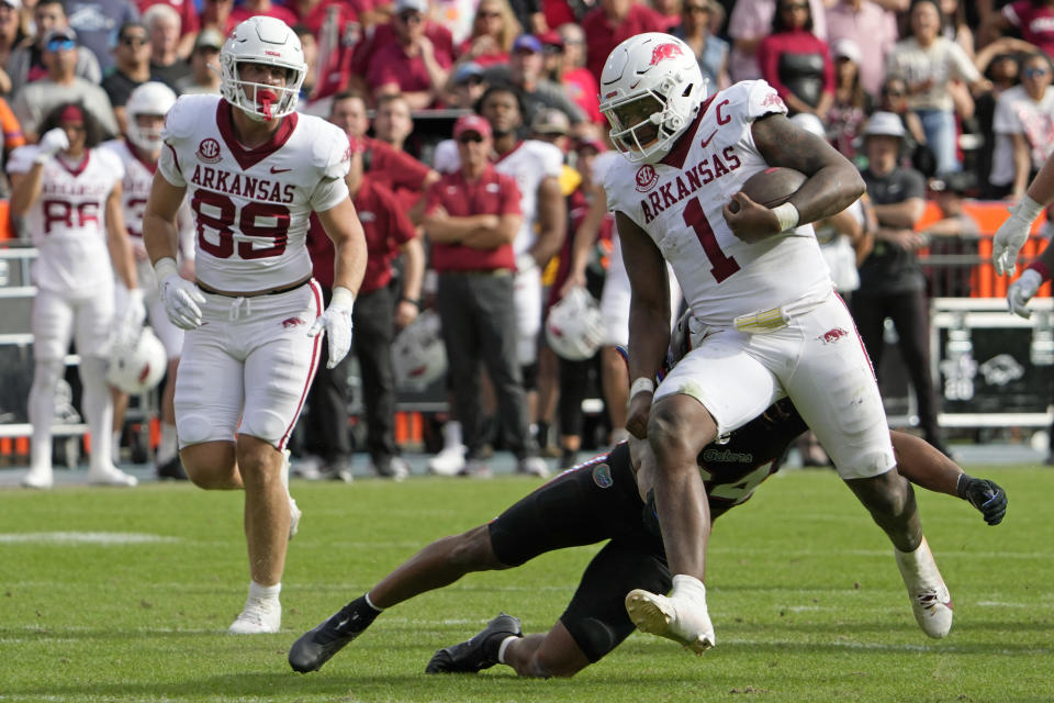 Arkansas quarterback KJ Jefferson (1) runs past Florida linebacker Mannie Nunnery during overtime in an NCAA college football game, Saturday, Nov. 4, 2023, in Gainesville, Fla. (AP Photo/John Raoux)