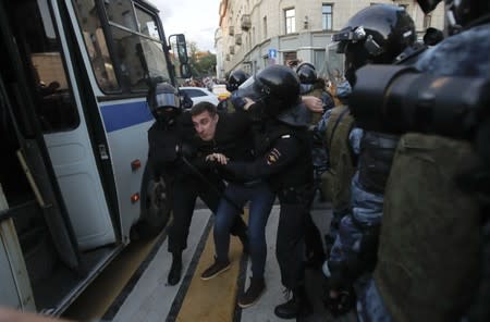 Law enforcement officers detain a man after a rally to demand authorities allow opposition candidates to run in a local election in Moscow