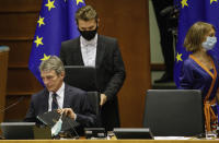 European Parliament President David Sassoli, left, prepares to open the plenary at the European Parliament in Brussels, Wednesday, May 27, 2020. The European Union is to unveil Wednesday a massive coronavirus recovery plan worth hundreds of billions of euros to help countries rebuild their ailing economies, but the bloc remains deeply divided over what conditions should be attached to the funds. (AP Photo/Olivier Matthys)