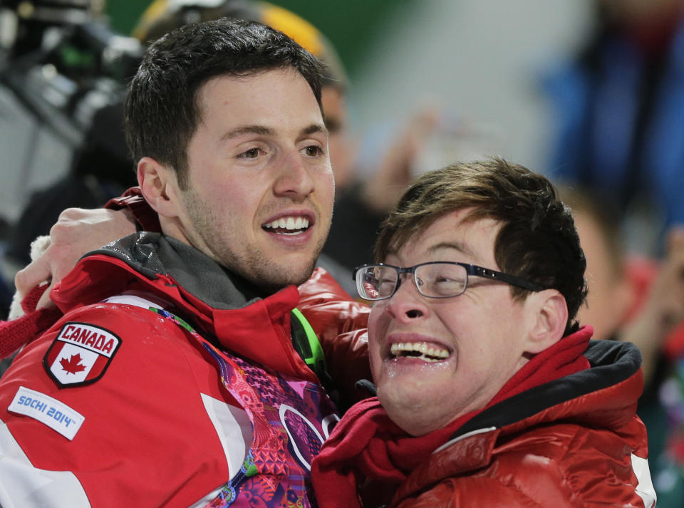 Canada's Alex Bilodeau, left, celebrates with his brother Frederic after winning the gold medal in the men's moguls final at the Rosa Khutor Extreme Park at the 2014 Winter Olympics, Monday, Feb. 10, 2014, in Krasnaya Polyana, Russia. (AP Photo/Andy Wong)