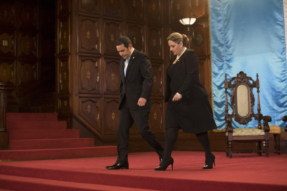 Guatemalan President Jimmy Morales, left, and Foreign Minister Sandra Jovel leave the National Palace after attending a welcoming ceremony for ambassadors, in Guatemala City, Thursday, Jan. 10, 2019. Guatemala's Constitutional Court overruled Morales' decision after all-night deliberations on five appeals, blocking Morales' decision to unilaterally end a U.N. anti-corruption commission. (AP Photo/Moises Castillo)