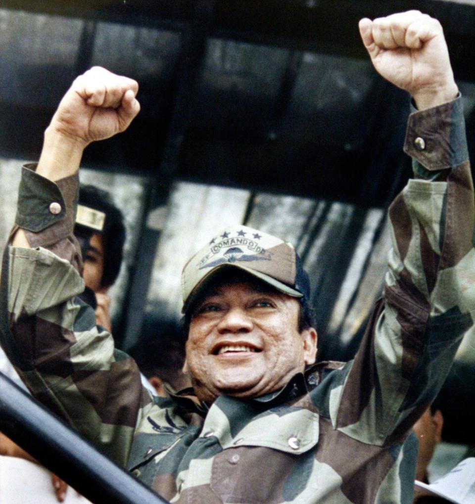 <p>Panamanian military strongman Gen. Manuel Noriega raises his fists to acknowledge the crowd’s cheers during a Dignity Battalion rally in Panama City, May 20, 1988. (AP Photo/John Hopper) </p>