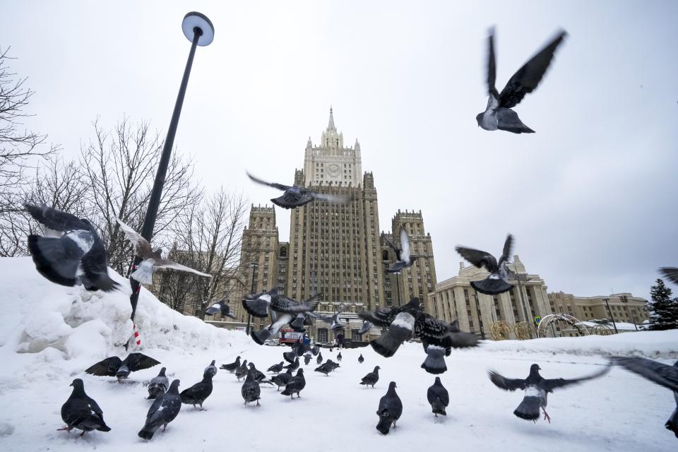 Pigeons take off in front of the Russian Foreign Ministry building in Moscow, Russia, Wednesday, Jan. 26, 2022. Russian Foreign Minister Sergey Lavrov said he and other top officials will advise President Vladimir Putin on the next steps after receiving written replies from the United States to the demands. Those answers are expected this week — even though the U.S. and its allies have already made clear they will reject the top Russian demands. (AP Photo/Alexander Zemlianichenko)