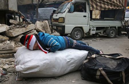 A child sleeps while waiting to be evacuated with others from a rebel-held sector of eastern Aleppo, Syria December 17, 2016. REUTERS/Abdalrhman Ismail