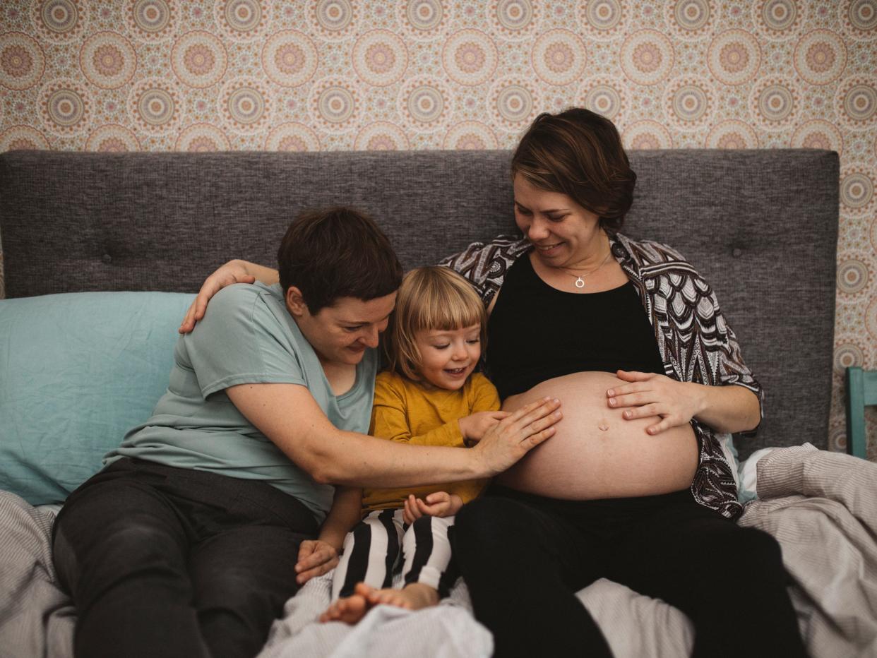 Mothers and daughter touching pregnant belly