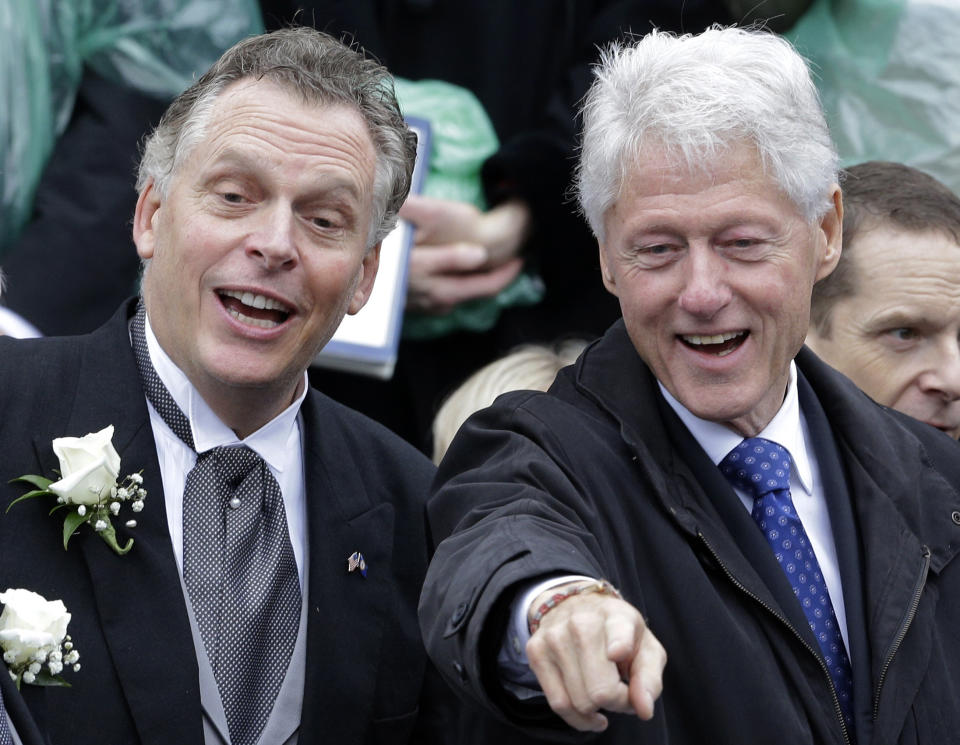 Virginia Gov. Terry McAuliffe, left, and former U.S. President Bill Clinton acknowledge supporters during inaugural ceremonies at the Capitol in Richmond, Va., Saturday, Jan. 11, 2014. McAuliffe was sworn in Saturday as the 72nd governor of Virginia. (AP Photo/Patrick Semansky)