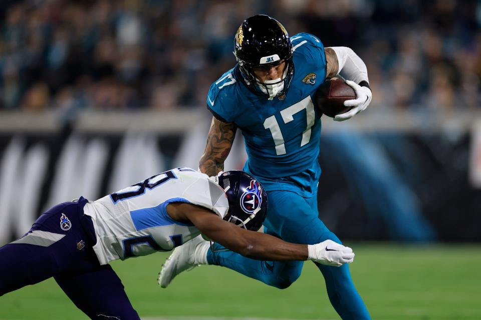 Jacksonville Jaguars tight end Evan Engram (17) is tackled by Tennessee Titans safety Joshua Kalu (28) during the second quarter of an NFL football regular season matchup AFC South division title game Saturday, Jan. 7, 2023 at TIAA Bank Field in Jacksonville. [Corey Perrine/Florida Times-Union]