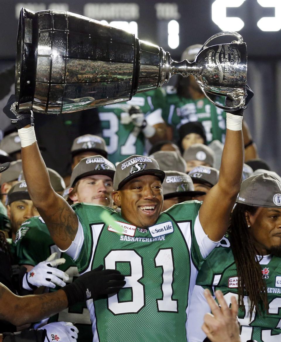 The Saskatchewan Roughriders Geroy Simon lifts the Grey Cup after they defeated the Hamilton Tiger-Cats in the CFL's 101st Grey Cup championship football game in Regina, Saskatchewan November 24, 2013. REUTERS/Mark Blinch (CANADA - Tags: SPORT FOOTBALL)