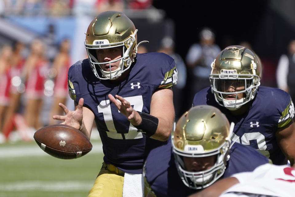 Notre Dame quarterback Jack Coan takes a snap from center in the shotgun formation during the first half of an NCAA college football game against Wisconsin Saturday, Sept. 25, 2021, in Chicago. (AP Photo/Charles Rex Arbogast)