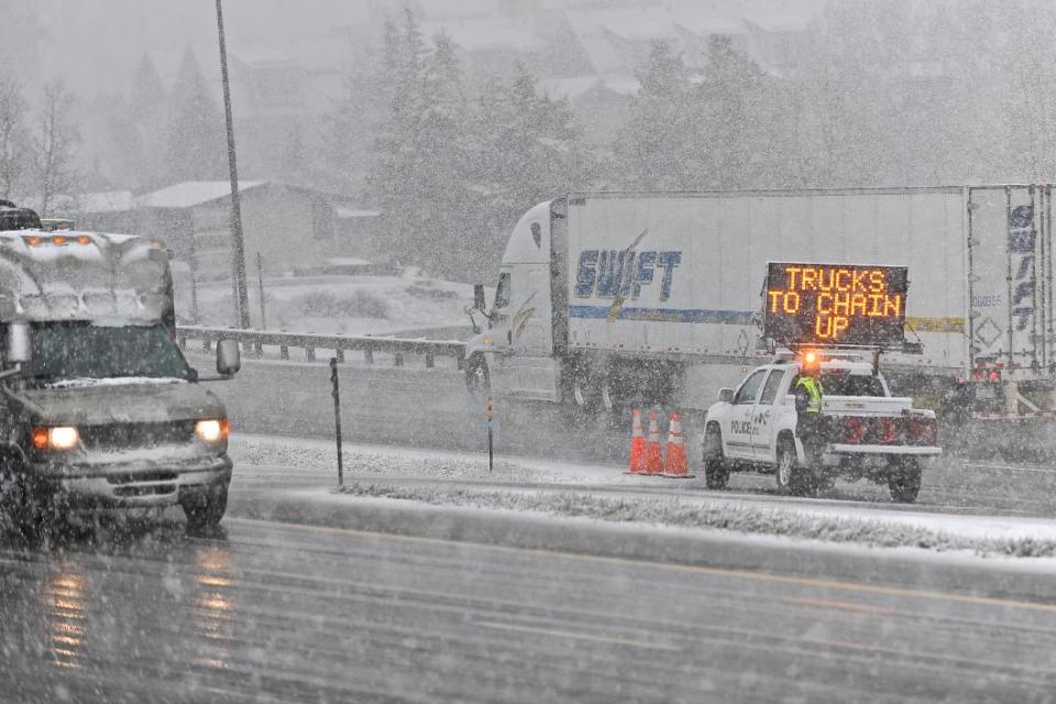 A truck moves off of Interstate I-70 to chain up before continuing eastward in Vail, Colo. on Sunday, May 11, 2014. The storm that ripped through the Vail Valley on Mother's Day caused numerous accidents and road closures. (AP Photo/The Vail Daily, Anthony Thornton)