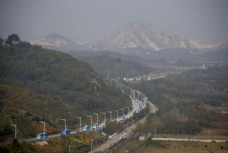 FILE PHOTO: Buses transporting South Korean participants for a reunion travel on the road leading to North Korea's Mount Kumgang resort, in the demilitarized zone (DMZ) separating the two Koreas in this picture taken from the Unification Observatory, just south of the DMZ in Goseong, South Korea, October 20, 2015. REUTERS/Kim Hong-Ji/File Photo