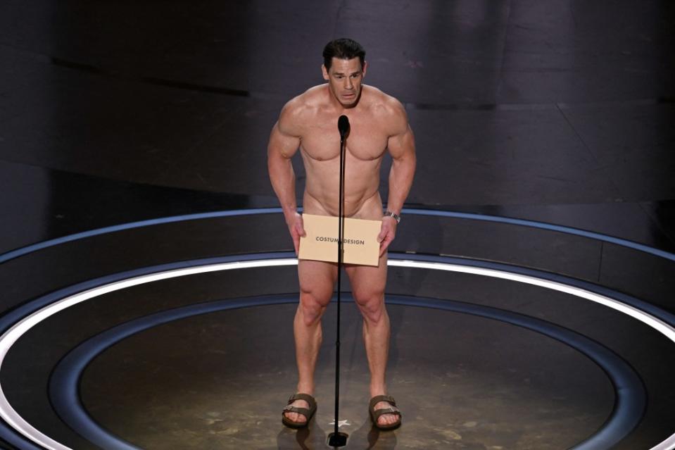 Much to everyone’s shock — and delight — Cena ended up going through with the presentation while holding the envelope in front of his genitals, which appeared to be covered with a modesty garment. PATRICK T. FALLON/AFP via Getty Images)