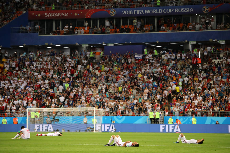 <p>The IR Iran players lie dejectedly on the pitch at the end of the 2018 FIFA World Cup Russia group B match between Iran and Portugal at Mordovia Arena on June 25, 2018 in Saransk, Russia. (Photo by Matthew Ashton – AMA/Getty Images) </p>