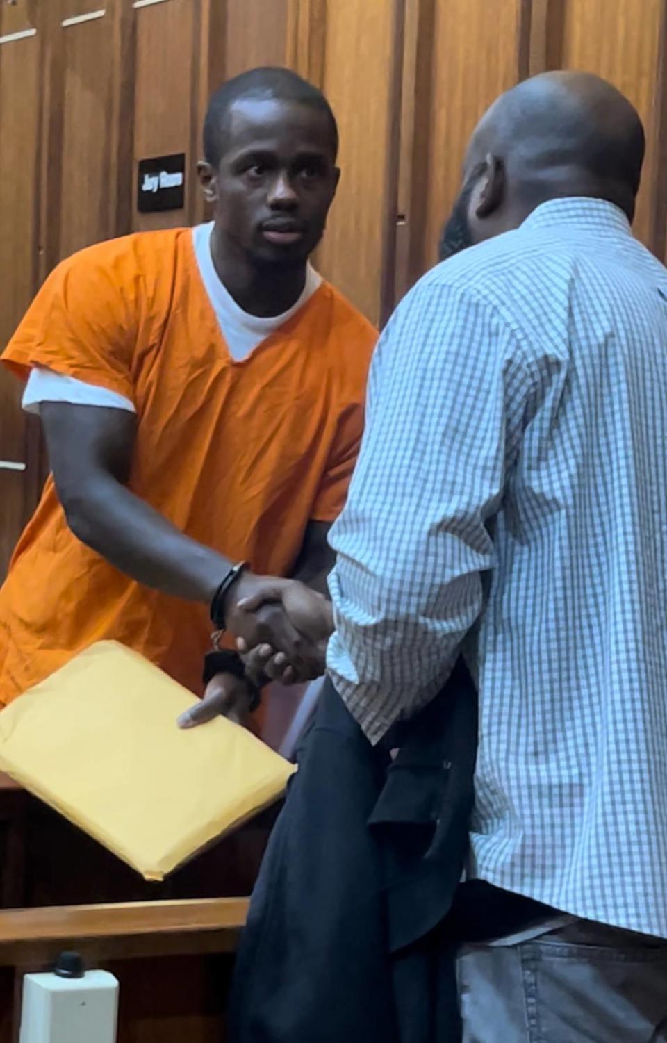 Emmanuel Jean, who was released from prison 16 years after being wrongfully accused, shakes the hand of a witness whose affidavit helped free him during an April hearing in front of Miami-Dade Circuit Court Judge Miguel De La O.