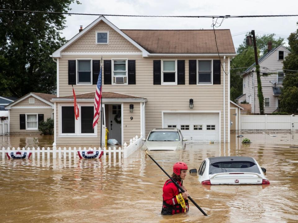 A New Market Volunteer Fire Company rescue crew member wades through high waters following a flash flood, as Tropical Storm Henri makes landfall, in Helmetta, New Jersey (AFP via Getty Images)