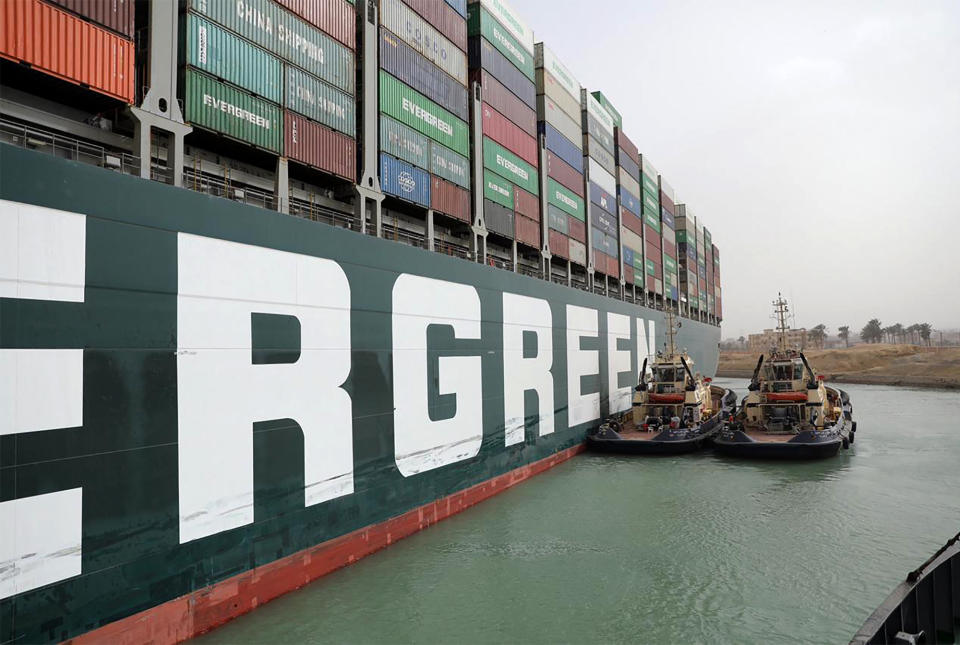 A handout picture released by the Suez Canal Authority on March 25, 2021 shows Egyptian tug boats trying to free Taiwan-owned MV Ever Given (Evergreen), a 400-metre- (1,300-foot-)long and 59-metre wide vessel, lodged sideways and impeding all traffic across the waterway of Egypt's Suez Canal. - Egypt's Suez Canal Authority said it was 