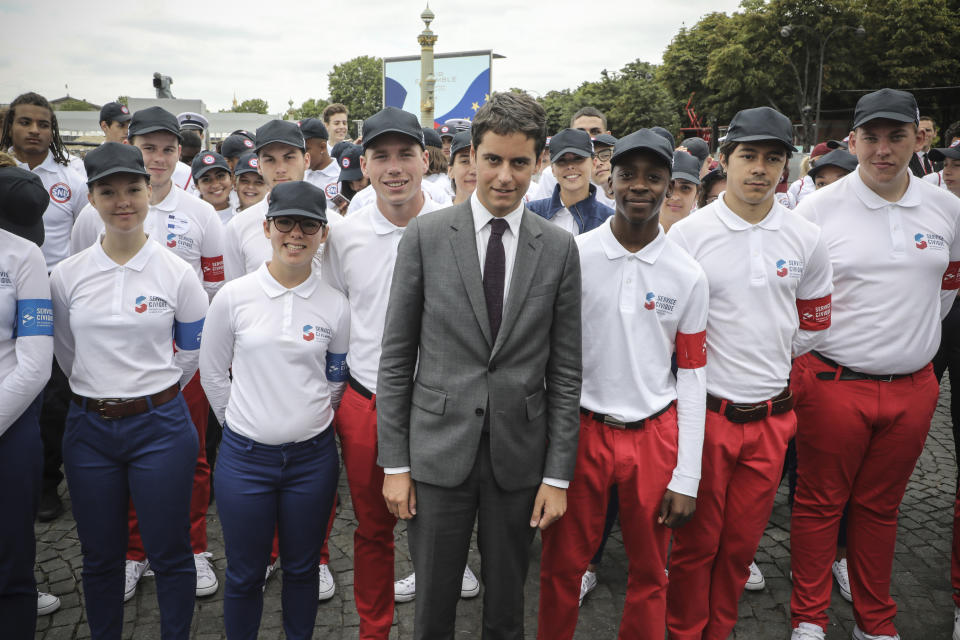 FILE - Then French Junior Minister for Education Gabriel Attal poses with members of the civic service and the universal national service SNU (Service National Universel) after the annual Bastille Day military parade on the Champs-Elysees in Paris Sunday July 14, 2019. French President Emmanuel Macron's choice to appoints a 34-year-old prime minister surprised many _ because of his young age and relatively short career. But Gabriel Attal has become in recent years one of the most prominent and ambitious figures on the French political scene, considering there's "nothing greatest than serving France." (Ludovic Marin/Pool via AP, File)