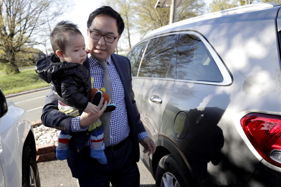 Andy Kim carries his 9-month-old son, August Kim, on his first day of school in Bordentown, N.J., in May. (Photo: Julio Cortez/AP)