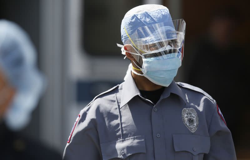 Security guard wears protective mask and shield outside Wykoff Hospital in Brooklyn during outbreak of the coronavirus disease (COVID-19) in New York