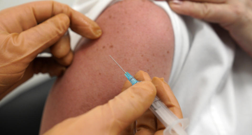 A person's arm shown receiving a vaccine.