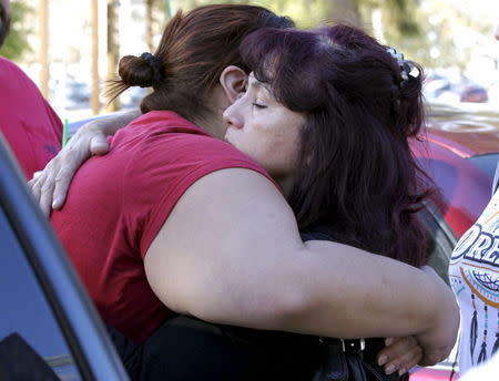 Teresa Hernandez (R) hugs Monique Gutierrez at the Rudy Hernandez Community Center as they wait for a relative who was not injured after a shooting rampage at the Inland Regional Center in San Bernardino, December 2, 2015. REUTERS/Alex Gallardo