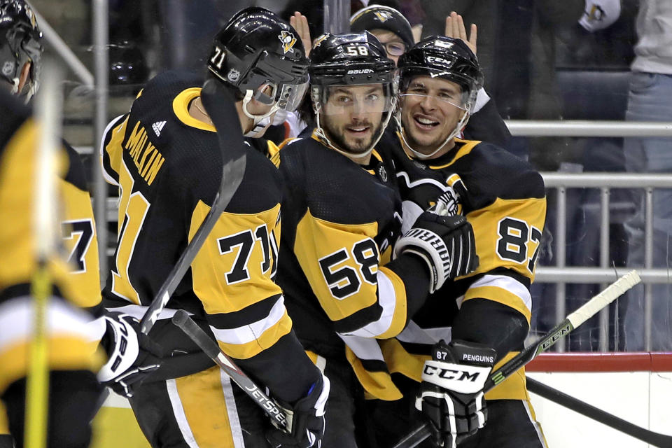 Pittsburgh Penguins' Kris Letang (58) celebrates his goal with Evgeni Malkin (71) and Sidney Crosby (87) during the second period of the team's NHL hockey game against the Montreal Canadiens in Pittsburgh, Friday, Feb. 14, 2020. (AP Photo/Gene J. Puskar)