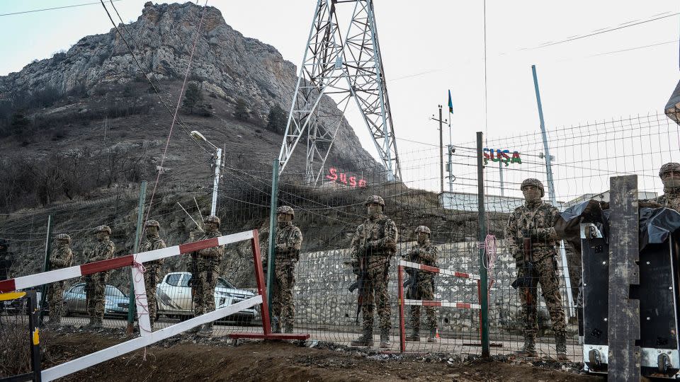 Azerbaijani servicemen stand guard at a checkpoint at the Lachin corridor, which links Nagorno-Karabakh with Armenia. - Tofik Babayev/AFP/Getty Images