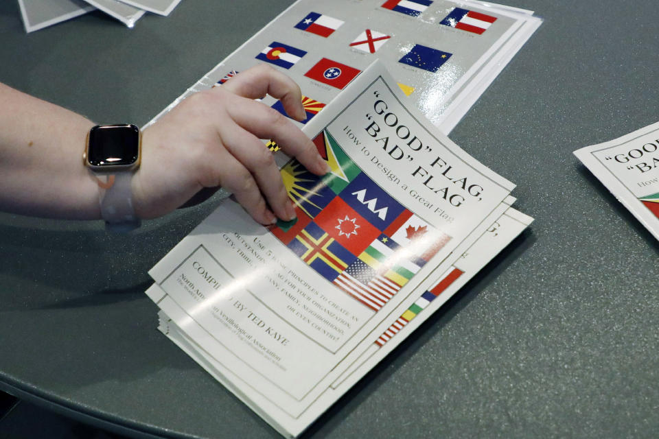 A member of the state Department of Archives and History prepares a handout of materials on how to design a flag for members, following the first meeting of the Flag Commission, Wednesday, July 22, 2020, in Jackson, Miss. The group has the duty to design a new Mississippi flag without the Confederate battle emblem and the banner must include the phrase, "In God We Trust." (AP Photo/Rogelio V. Solis)