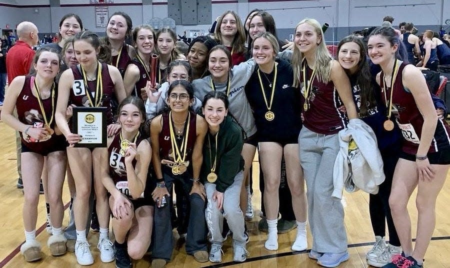 Ayer-Shirley girls' indoor track athletes celebrate winning the Mid-Wach D Championship on Friday at Fitchburg High.