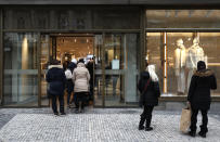 People enter a store in Prague, Czech Republic, Thursday, Dec. 3, 2020. A sign of normalcy has returned to the Czech Republic ahead of the Christmas period after the government eased some of its most restrictive measures imposed to contain the recent massive surge of coronavirus infections. On Thursday all stores, shopping malls, restaurants, bars and hotels were allowed to reopen. (AP Photo/Petr David Josek)