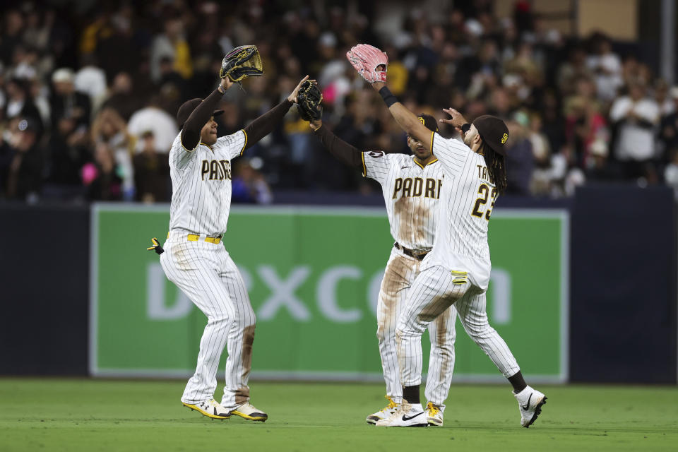 San Diego Padres' Juan Soto, left, celebrates with Trent Grisham, background, and Fernando Tatis Jr. after defeating the Padres defeated the Cleveland Guardians in a baseball game Tuesday, June 13, 2023, in San Diego. (AP Photo/Derrick Tuskan)