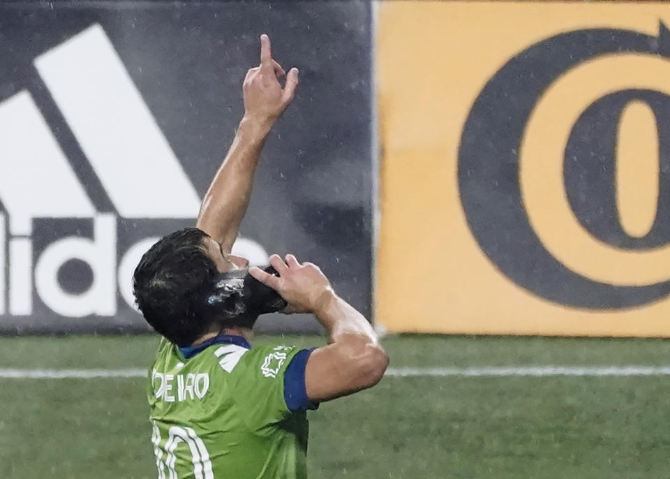 Seattle Sounders midfielder Nicolas Lodeiro pretends to use his shoe as a phone in celebration of scoring his first penalty kick goal against Los Angeles FC in the first half of an MLS soccer match, Friday, Sept. 18, 2020, in Seattle. (AP Photo/Ted S. Warren)