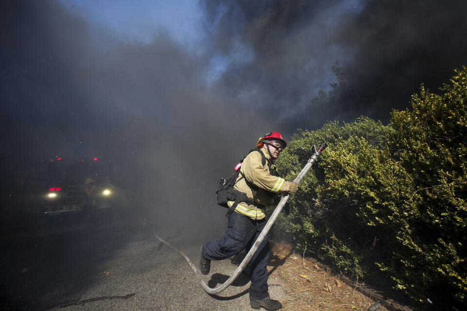 A firefighter battles a wildfire near a ranch in Simi Valley, Calif., Wednesday, Oct. 30, 2019. (AP Photo/Ringo H.W. Chiu)