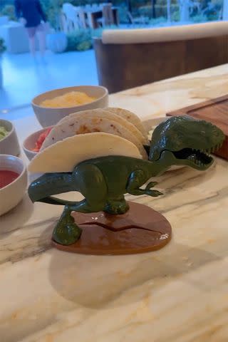 <p>Chrissy Teigen/Instagram</p> Chrissy Teigen shows off a dinosaur-shaped taco holder.