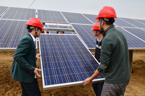 Chinese workers install solar panels at a photovoltaic power station in Chaohu city, Nov. 5, 2015.