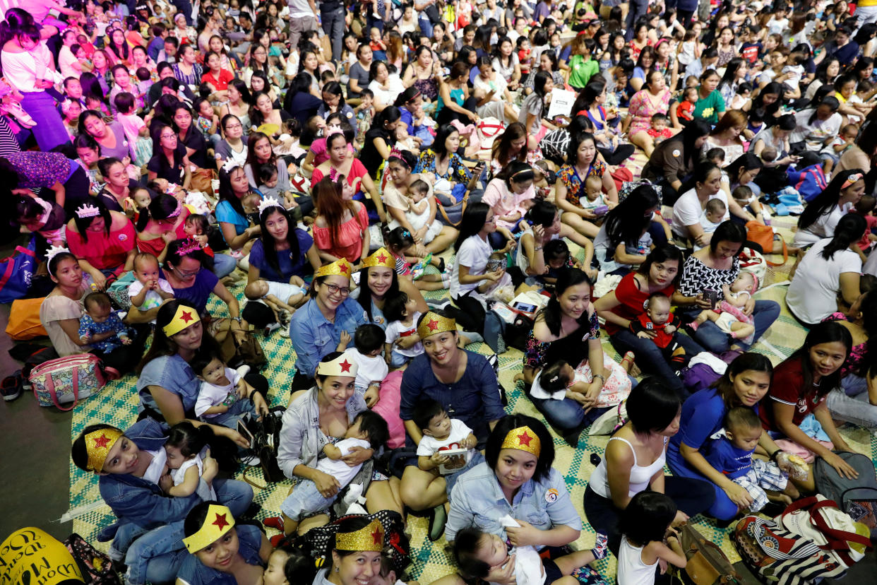 Filipino mothers hold their babies during a one-minute simultaneous breastfeeding event. REUTERS/Dondi Tawatao