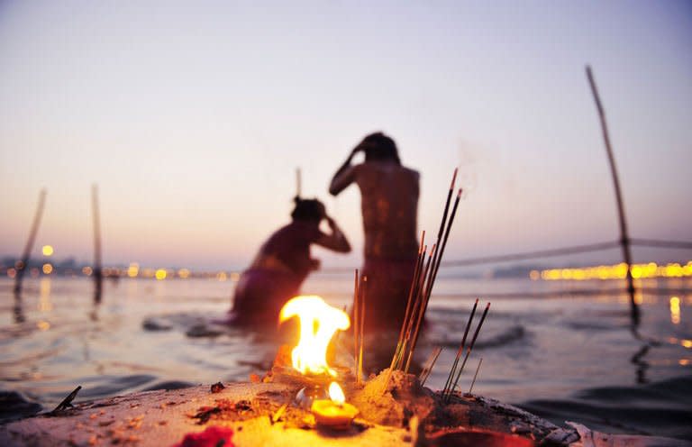 Hindu devotees bathe at Sangam, the confluence of the Yamuna, Ganges and mythical Saraswati rivers after sundown at the Kumbh Mela in Allahabad on February 9, 2013