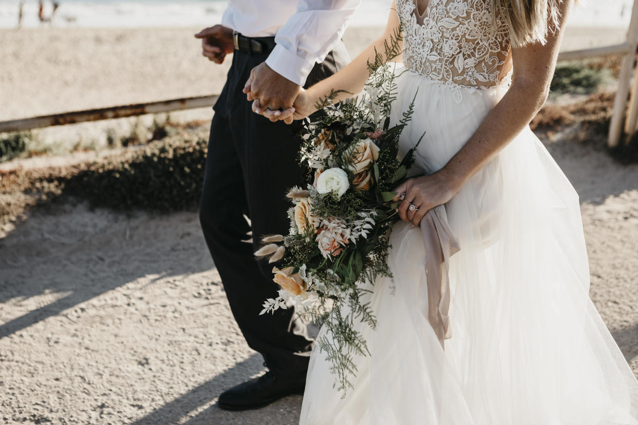 A bride and groom hold hands on their wedding day