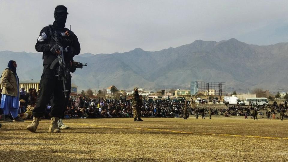 阿富汗帕爾旺省恰裏卡爾市一場公開體罰大會上一名塔利班戰鬥人員持槍站崗（8/12/2022）