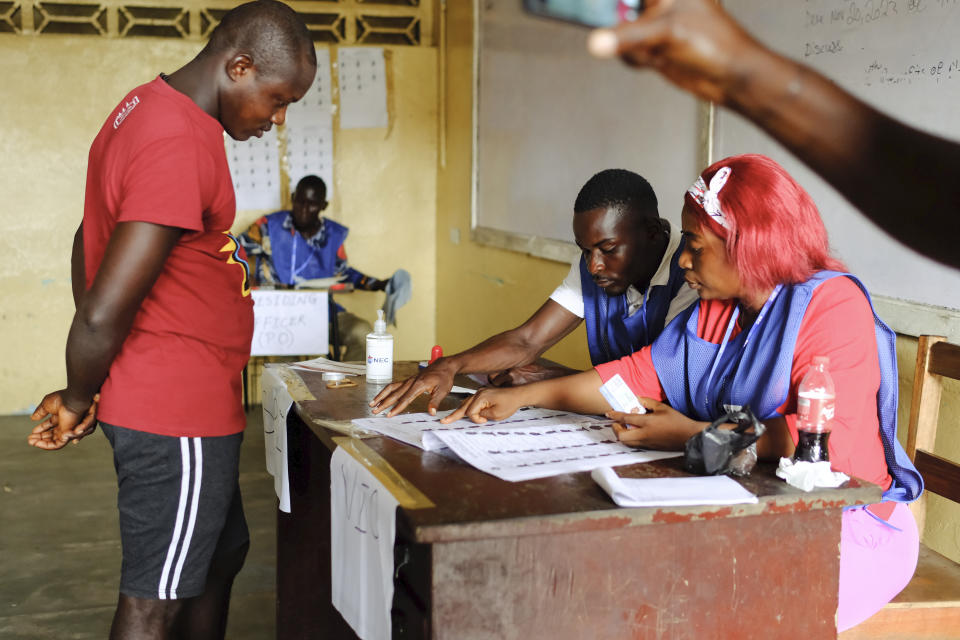 Election officials check the voters registrations as people lineup to vote in the second round of presidential elections in Monrovia, Liberia, Tuesday, Nov. 14, 2023. Liberian President George Weah, faces a tight runoff election as he seeks to defeat Joseph Boakai, a repeat challenger, and earn a second term in the West African nation. (AP Photo/Rami Malek)