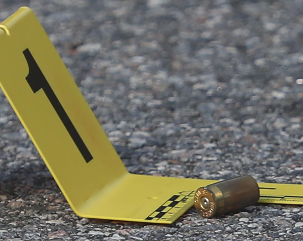 An evidence marker sits beside a spent shell casing at the scene of a triple murder on Dr. Martin Luther King Drive on Wednesday July 12, 2023.